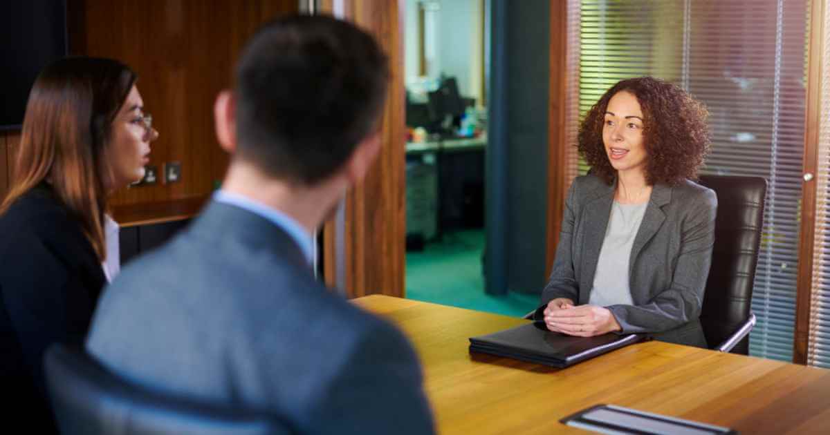 Woman looking at her interviewers while answering their questions