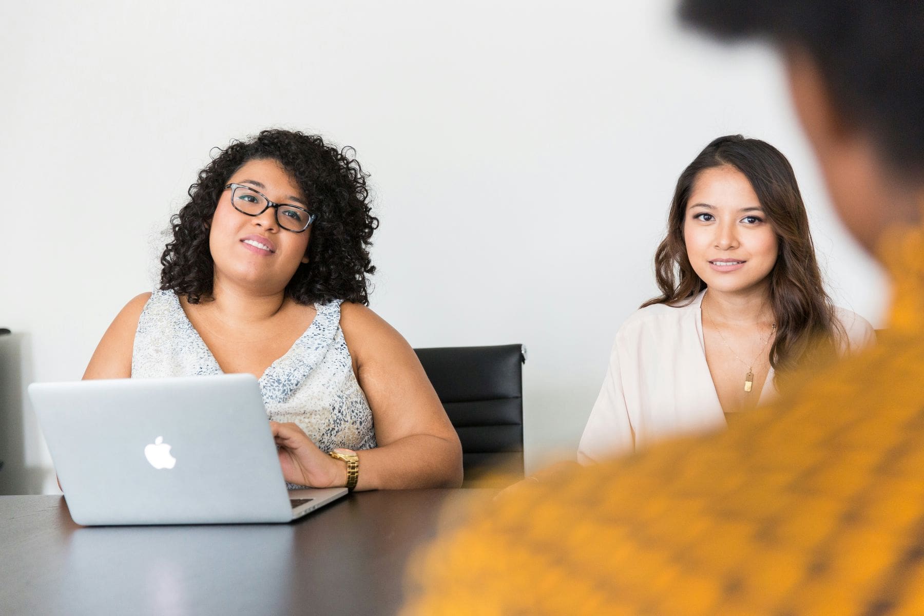 Two women listening to an employee candidate during a panel interview session