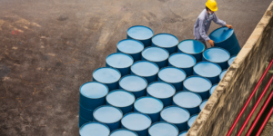 A construction working lifting an oil barrel